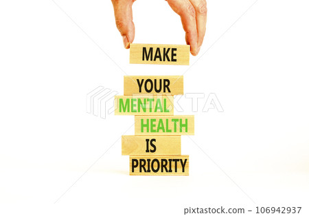 Mental health psychological symbol. Concept words Make your mental health a priority on wooden block. Beautiful white table white background. Businessman hand. Psychological mental health concept. 106942937