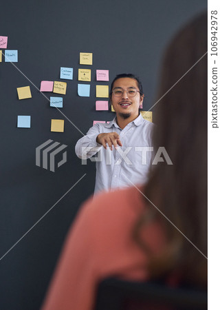 Meeting, brainstorming and presentation with team, man speaker and sticky note with leadership at startup. Collaboration, people in strategy planning workshop and ideas with presenter and audience Meeting, brainstorming and presentation with team, man speaker and sticky note with leadership at startup. Collaboration, people in strategy planning workshop and ideas with presenter and audience 106942978