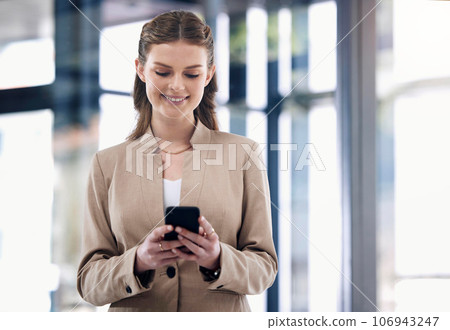 Sorting business matters straight from her phone. Shot of a young businesswoman using a cellphone in an office. 106943247