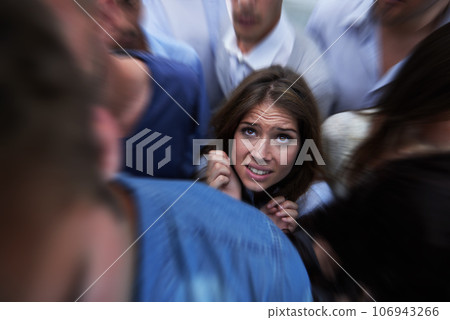 Drowning in people. Shot of a fearful young woman feeling trapped by the crowd. 106943266
