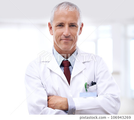 Healthcare, portrait of man doctor with arms crossed and in a hospital. Medical health wellness, specialist or stand and confident professional mature male surgeon or nurse at clinic for support 106943269