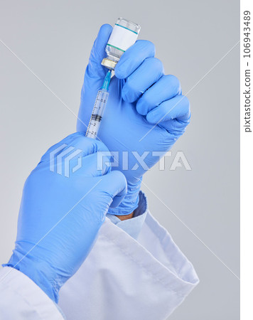 Vaccine vial, needle and doctor hands in studio for safety, healthcare and pharmaceutical medicine. Closeup person, vaccination and injection bottle for virus, immunity and medical antibiotics drugs 106943489