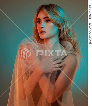 Quietly confident. Studio shot of an attractive young woman posing against a blue background. 106943493