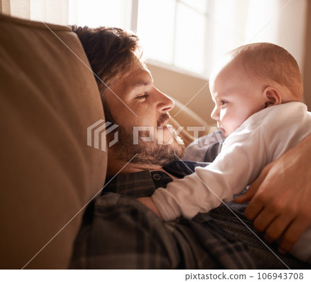 Smile, father and bonding with baby on sofa in home living room or playing together. Happiness, care and dad cuddle with infant, newborn or child on couch in lounge, having fun or enjoying relax time 106943708