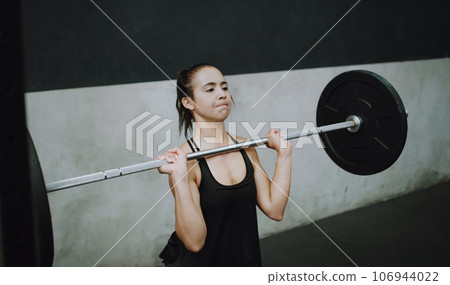 Weightlifting, fitness and woman lifting barbell in gym for training, exercise and intense workout. Deadlift, strong muscle and female body builder lift weights for challenge, wellness and strength 106944022