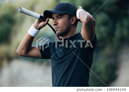 Young tennis player adjusting his cap during a match 106944149