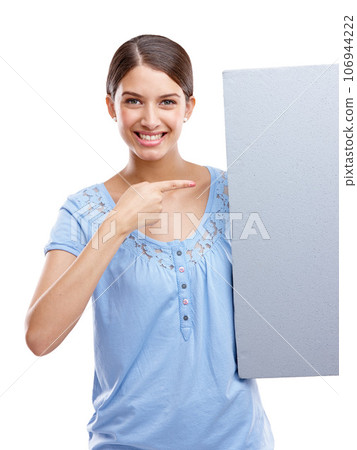 Portrait, pointing and blank sign with a woman in studio isolated on a white background holding a poster for branding. Logo, marketing and brand with a female showing mockup space for advertising 106944222