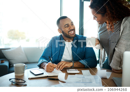 Couple talk about budget, finance and bills with paperwork of financial information, happy with savings and income. Mortgage, insurance and taxes, man and woman laugh together with home bookkeeping 106944268