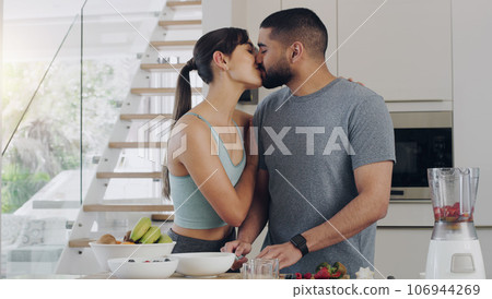 Love, cooking and couple kissing in kitchen while preparing a healthy, fresh and diet breakfast. Happy, bonding and young man and woman with intimate moment while cutting fruit for smoothies together Love, cooking and couple kissing in kitchen while preparing a healthy, fresh and diet breakfast. Happy, bonding and young man and woman with intimate moment while cutting fruit for smoothies together 106944269