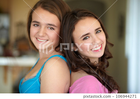 Happy sisters, portrait and standing back to back for family, friends or teens together at home. Face of female people, siblings and smile for friendship, relationship or young women in the house Happy sisters, portrait and standing back to back for family, friends or teens together at home. Face of female people, siblings and smile for friendship, relationship or young women in the house 106944271