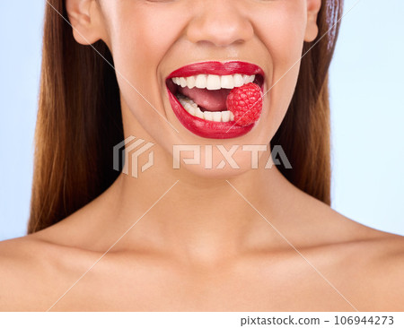 Beauty, health and raspberry with mouth of woman in studio for nutrition, diet or detox. Cosmetics, natural and self care with girl model eating fruit on blue background for wellness, organic or glow 106944273