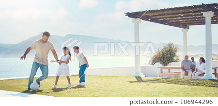 Family, father and playing football at beach on vacation, having fun and bonding. Soccer, sports and happy dad play with kids or children for exercise, care and enjoying holiday at seashore in summer 106944296