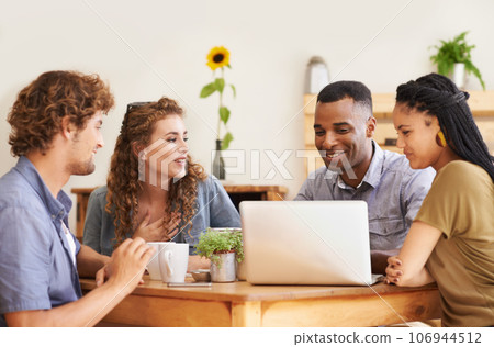 In good company. A group of friends sitting together in a coffee shop with a laptop. 106944512
