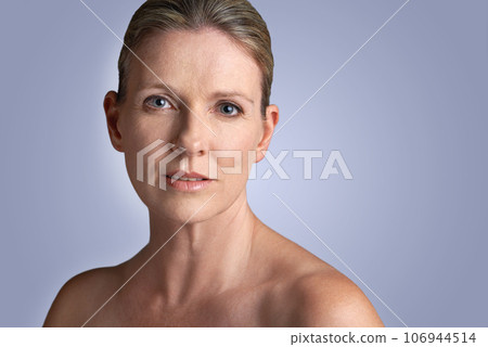 Face, beauty and portrait of mature woman doing cosmetic skincare facial isolated in a blue studio background. Cosmetics, care and old female model calm with natural skin due to anti aging 106944514