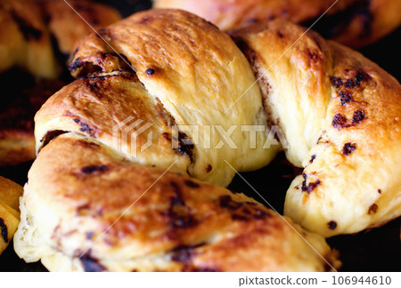 Chocolate croissant, food and bakery cooking for catering service, breakfast or baked meal at cafe. Closeup of fresh or crispy bread or dessert for eating, sweet cake or nutrition roll in the kitchen Chocolate croissant, food and bakery cooking for catering service, breakfast or baked meal at cafe. Closeup of fresh or crispy bread or dessert for eating, sweet cake or nutrition roll in the kitchen 106944610