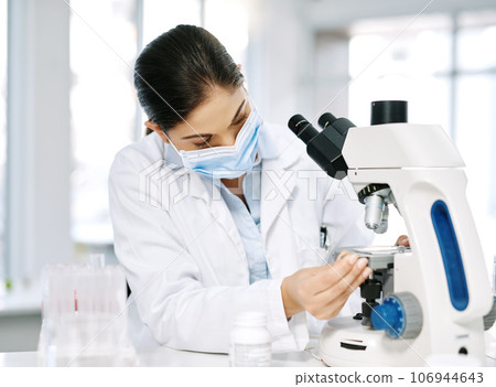 Some new samples came in for testing. Shot of a young scientist using a microscope in a lab. 106944643