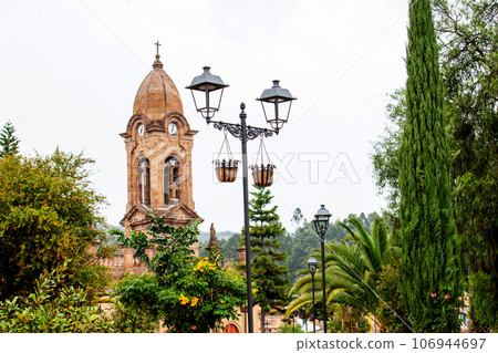 Beautiful central square and the San Jeronimo Parish Temple of the small town of Nobsa well known for the traditional handmade ruanas in the region of Boyaca in Colombia Beautiful central square and the San Jeronimo Parish Temple of the small town of Nobsa well known for the traditional handmade ruanas in the region of Boyaca in Colombia 106944697