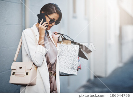 Phone call, shopping bag and woman in city for communication, discount or promotion of fashion. News, gift offer and customer or person with clothes sale, wealth and ecommerce or product review chat 106944796