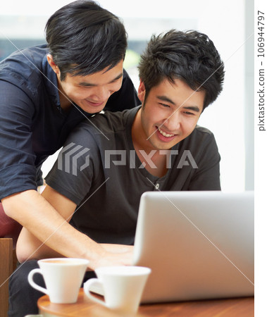 Happy, streaming and a gay couple with a laptop for a movie, internet search or reading email. Smile, love and Asian men with a computer for online information, movie choice or show together Happy, streaming and a gay couple with a laptop for a movie, internet search or reading email. Smile, love and Asian men with a computer for online information, movie choice or show together 106944797