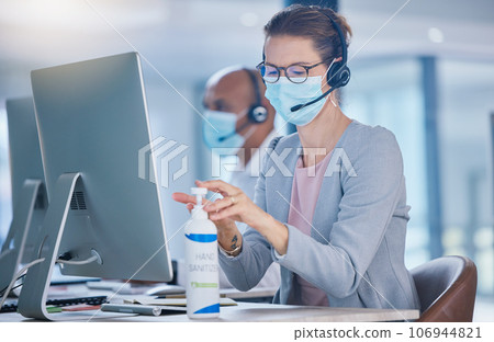 Sanitize, hygiene and compliance with covid19 regulations at call center with crm agent cleaning workstation. Woman working in customer service, making sure to leave desk fresh for the next operator Sanitize, hygiene and compliance with covid19 regulations at call center with crm agent cleaning workstation. Woman working in customer service, making sure to leave desk fresh for the next operator 106944821