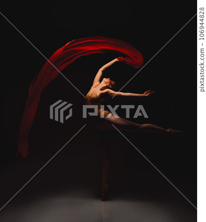 She lives for the arts. Shot of a performer dancing against a dark background. 106944828