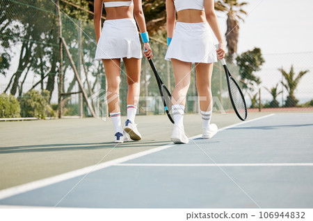 Time to get some practise in. two unrecognisable tennis players walking together on the court. Time to get some practise in. two unrecognisable tennis players walking together on the court. 106944832