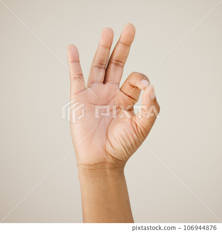 Youre doing just fine. Cropped shot of a man showing a hand sign against a studio background. Youre doing just fine. Cropped shot of a man showing a hand sign against a studio background. 106944876