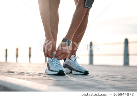 Fitness, running and man tie shoes by ocean ready for exercise, marathon training and cardio workout. Start sports mockup, athlete and feet of male runner with shoelace for wellness and health Fitness, running and man tie shoes by ocean ready for exercise, marathon training and cardio workout. Start sports mockup, athlete and feet of male runner with shoelace for wellness and health 106944878