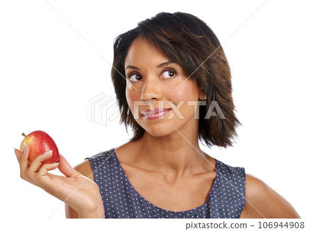 Fruit, thinking or black woman eating an apple in studio on white background with marketing mockup space. Choices, ideas or thoughtful African girl advertising a healthy natural diet for wellness 106944908