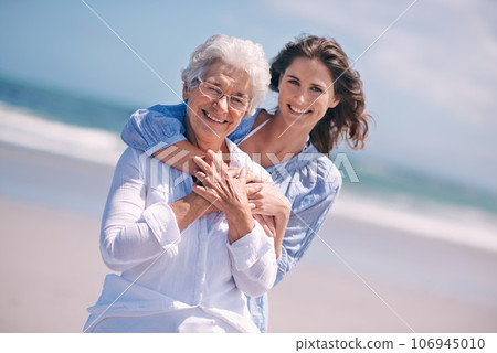 Portrait, young woman and hug her senior mother or smile or on the beach and together outdoors. Senior citizen, happy family and embracing with adult daughter or peace or freedom at sea for travel Portrait, young woman and hug her senior mother or smile or on the beach and together outdoors. Senior citizen, happy family and embracing with adult daughter or peace or freedom at sea for travel 106945010