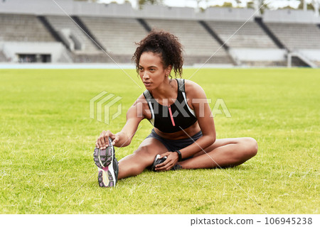 Woman, athlete and stretching legs on grass at stadium getting ready for running, workout or exercise. Active and sporty female person or runner in warm up leg stretch, athletics or fitness on field Woman, athlete and stretching legs on grass at stadium getting ready for running, workout or exercise. Active and sporty female person or runner in warm up leg stretch, athletics or fitness on field 106945238