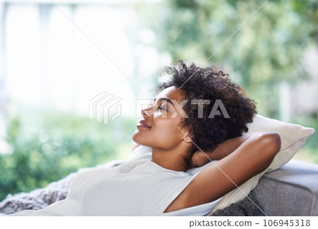 Relax, smile and black woman on sofa sleeping, afternoon nap and rest in calm apartment on weekend. Sleep, daydream ideas and girl on couch relaxing, self care and stress free chill time in lounge. 106945318