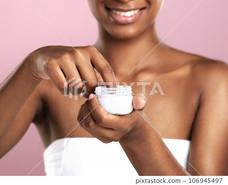 Hands, skincare cream and woman with container in studio isolated on a pink background. Dermatology product, creme and Indian female model with cosmetics, sunscreen lotion or moisturizer for beauty. 106945497