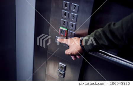 Man, hands and pressing button in elevator for transportation in building, floor or number indoors. Hand of male person selecting control on machine or lift for level up or down on touch panel 106945520