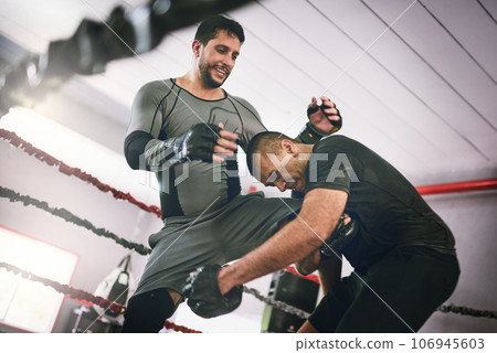 What a shot out of nowhere. Shot of two young male boxers facing each other in a training sparing match inside of a boxing ring at a gym during the day. What a shot out of nowhere. Shot of two young male boxers facing each other in a training sparing match inside of a boxing ring at a gym during the day. 106945603