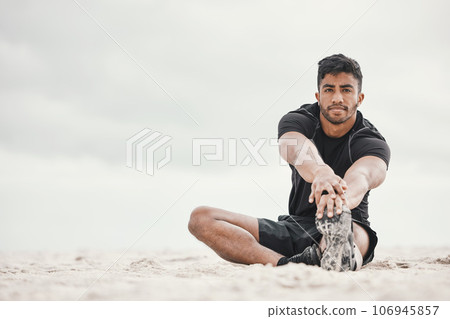 Make time for the things that give you more time. a young man stretching on the beach. Make time for the things that give you more time. a young man stretching on the beach. 106945857