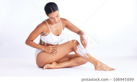 Skincare, legs and shaving, woman in studio sitting with hand on leg and razor for hair removal product placement. Smooth shave, skin and beauty, body care mockup, girl isolated on white background. 106945899