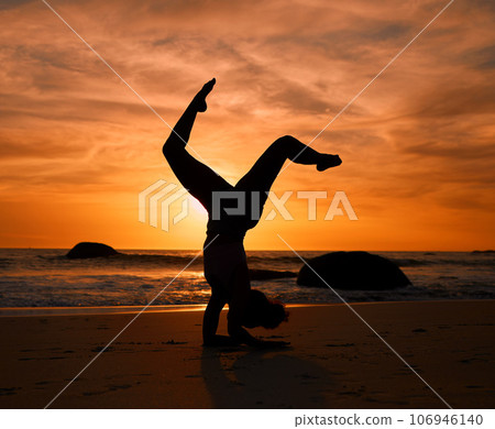 Yoga, silhouette or handstand pose on sunset beach, ocean or sea in evening workout or relax exercise training. Yogi, woman or sand balance at sunrise for healthcare wellness fitness or strong body Yoga, silhouette or handstand pose on sunset beach, ocean or sea in evening workout or relax exercise training. Yogi, woman or sand balance at sunrise for healthcare wellness fitness or strong body 106946140