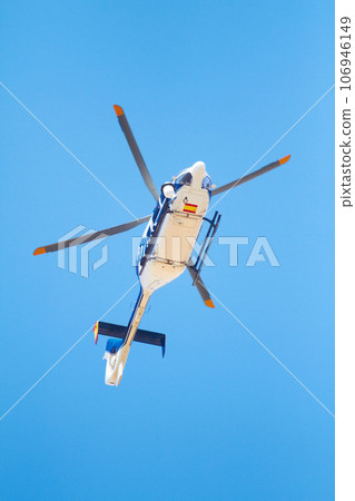 Canvasing the area. Low angle shot of a police helicopter in the sky. 106946149