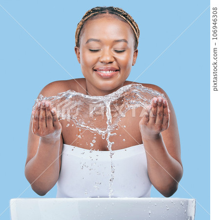 Your skin will always need moisture. Studio shot of an attractive young woman washing her face against a blue background. Your skin will always need moisture. Studio shot of an attractive young woman washing her face against a blue background. 106946308