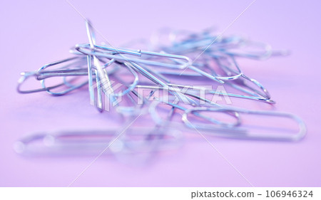 Paper clips together in pile, connected and a chain on purple background. Office supplies, organization and project management with paperclip for business strategy and planning to organize paperwork. Paper clips together in pile, connected and a chain on purple background. Office supplies, organization and project management with paperclip for business strategy and planning to organize paperwork. 106946324