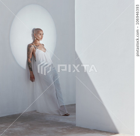 Beauty doesnt belong in the depths of your shadow. Shot of an attractive young woman posing in a white dress and leaning against a wall. Beauty doesnt belong in the depths of your shadow. Shot of an attractive young woman posing in a white dress and leaning against a wall. 106946393