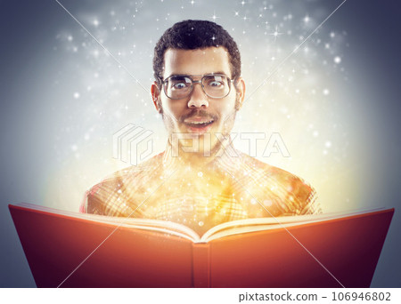 Bewitched by its hidden tales. A cropped shot of a young adult reading a book with glowing pages. 106946802