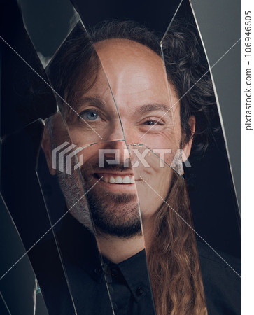 Mental health, personality disorder, schizophrenia or bipolar. Portrait of different horror face in a broken mirror of smile, split or creepy weird smiling expression or reflection on a glass surface Mental health, personality disorder, schizophrenia or bipolar. Portrait of different horror face in a broken mirror of smile, split or creepy weird smiling expression or reflection on a glass surface 106946805