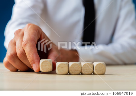 Businessman placing five blank wooden dices in a row 106947019
