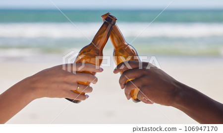 Hands, beer and beach with a couple toast outdoor during summer vacation or holiday in nature together. Cheers, alcohol or celebration with a man and woman drinking while bonding by the ocean or sea Hands, beer and beach with a couple toast outdoor during summer vacation or holiday in nature together. Cheers, alcohol or celebration with a man and woman drinking while bonding by the ocean or sea 106947170