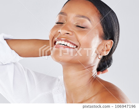 Face, happy and smile with a model black woman in studio on a gray background for freedom or expression. Wellness, beauty and cosmetics with an attractive young female laughing or joking indoor 106947196