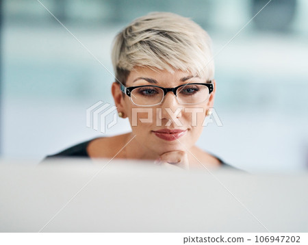 Success is an all day hustle. Shot of a young businesswoman working on a computer in an office. Success is an all day hustle. Shot of a young businesswoman working on a computer in an office. 106947202