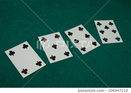 Old west era playing card on gambling table. 4,5,6 and 7 of clubs. 106947210