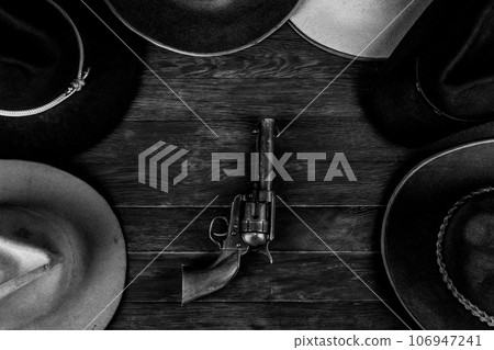Gun with old west hats on table. Top view. 106947241